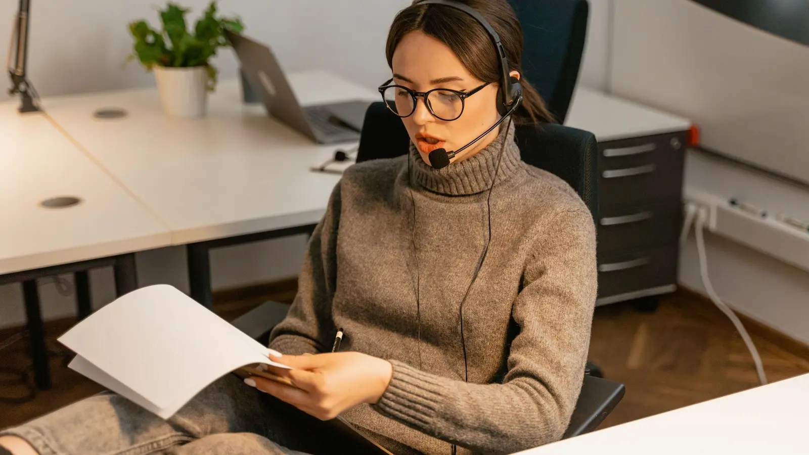 Headset auf Schreibtisch im Homeoffice-Setup für Videocalls und Online-Meetings