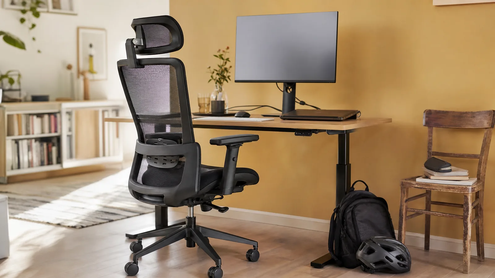 Ein ergonomischer Bürostuhl mit Netzrücken, verstellbaren Armlehnen und Kopfstütze steht an einem Schreibtisch, ohne Person – Symbolbild zu «Ergonomischer Bürostuhl: Die 5 besten Modelle im Vergleich»